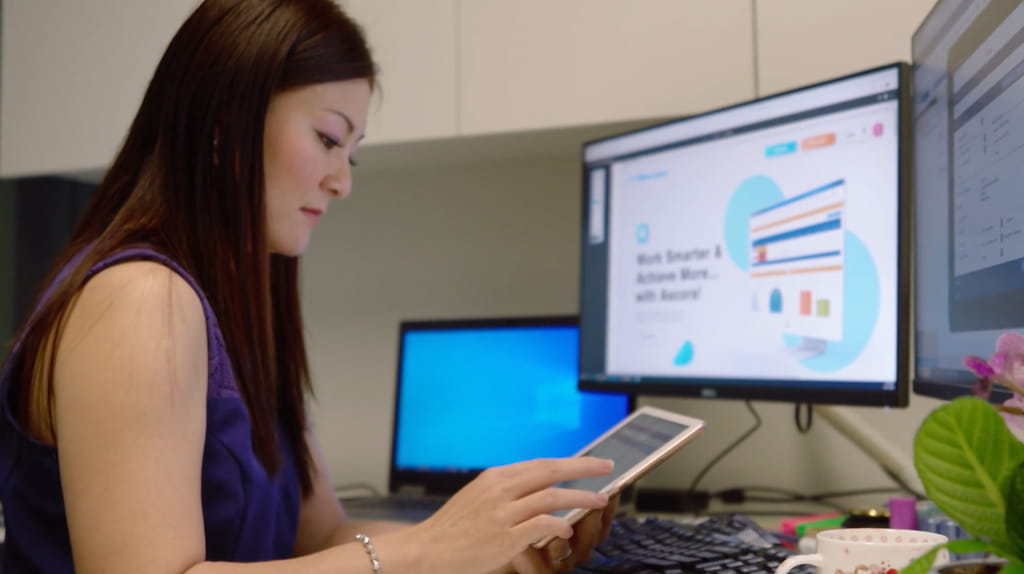 Office scene featuring a person using an iPad.